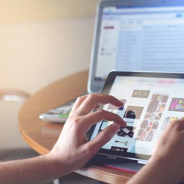 Woman with tablet and laptop on desk